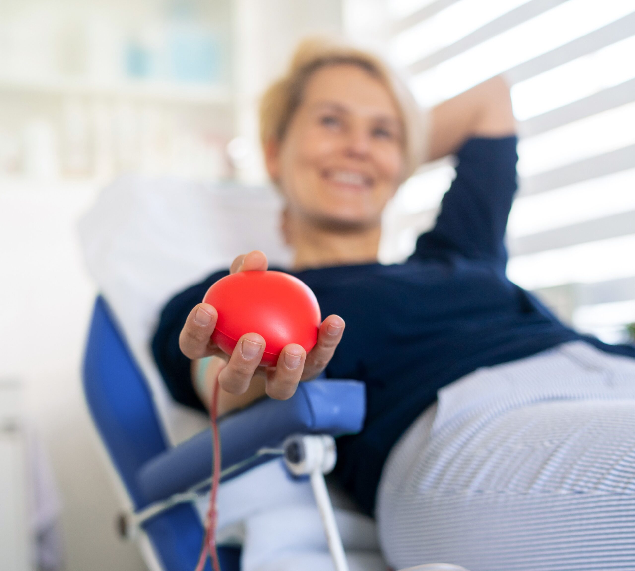 A young woman laying happy while donating her blood